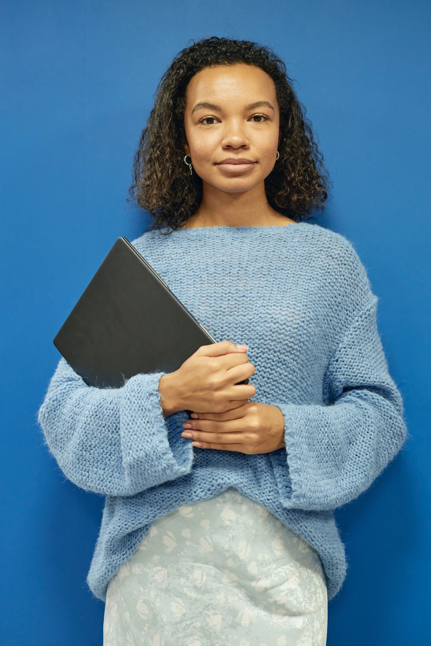 Portrait of a professional woman holding a laptop
