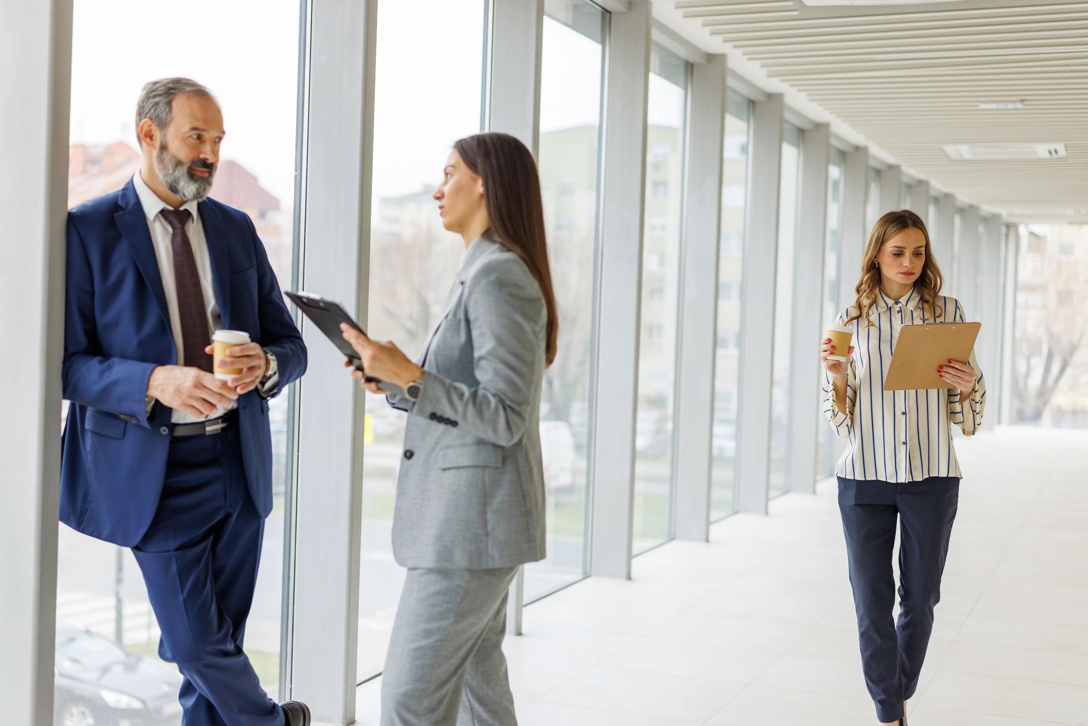 Business professionals collaborating in an office hallway